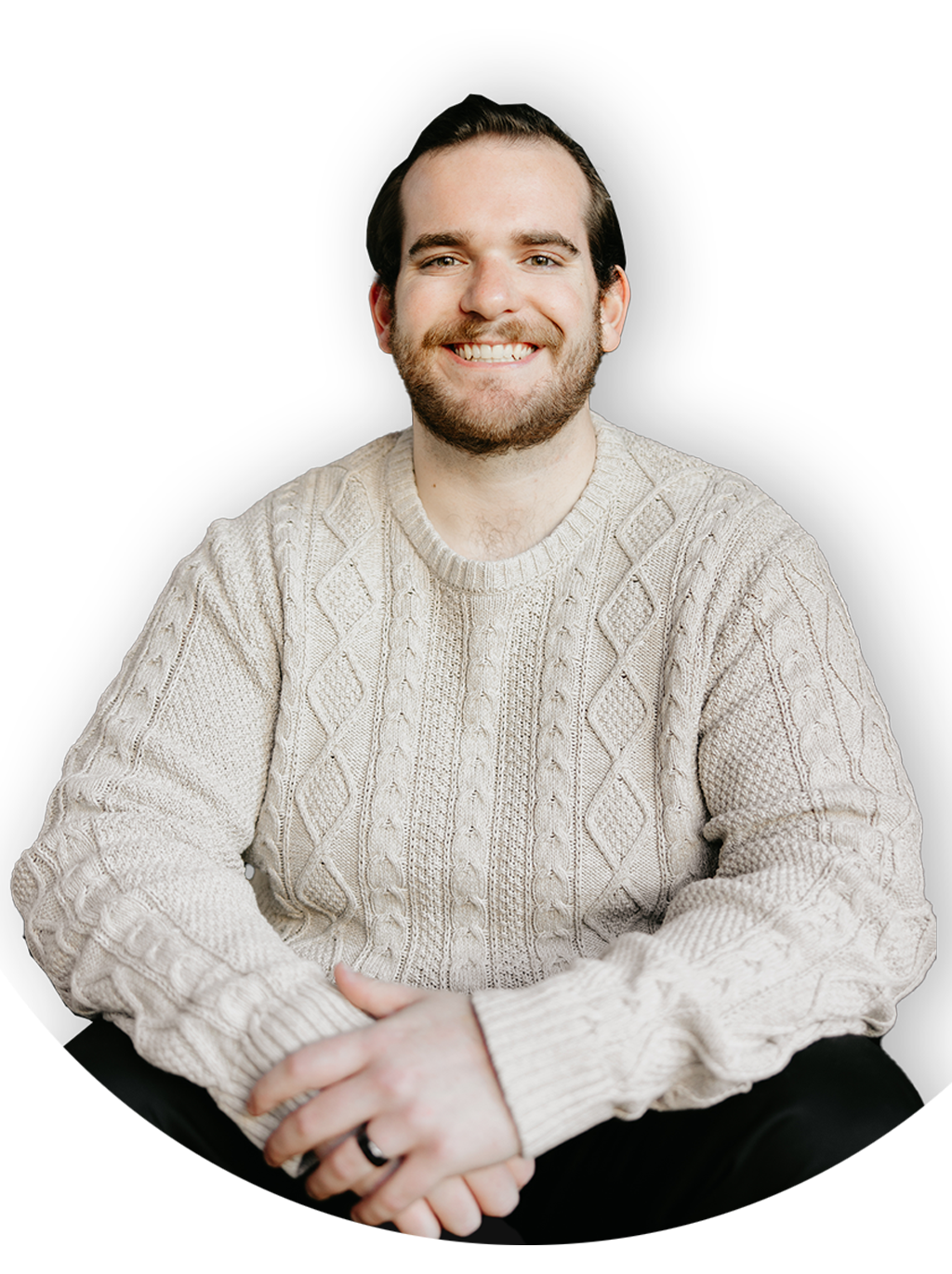 Austin Boardman Headshot. He is wearing a tan cable knit sweater